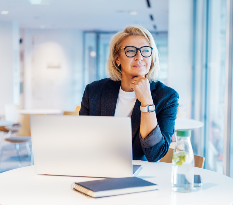Confident med spa owner working on a laptop in a modern office, researching malpractice insurance options.